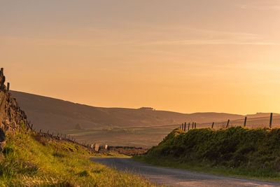 Road amidst landscape against sky during sunset