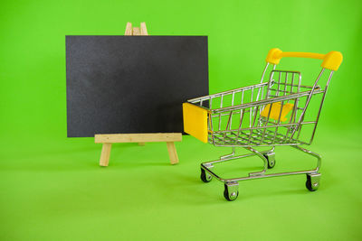 Empty chairs against green background