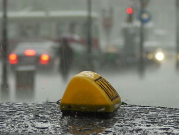 Close-up of yellow car on wet street