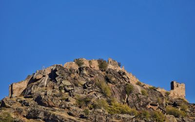 Scenic view of cliff against clear blue sky