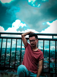 Portrait of young man against railing