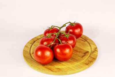 Close-up of tomatoes on table against white background