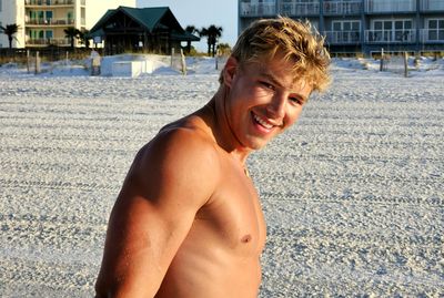 Portrait of young man standing at beach