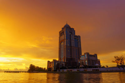 Buildings at waterfront during sunset