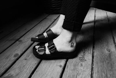 Low section of woman standing on hardwood floor