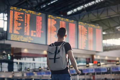 Traveling by airplane. man walking with backpack and suitcase walking through airport terminal.