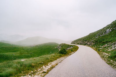 Road amidst mountains against sky