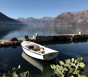 Boat moored on lake against sky