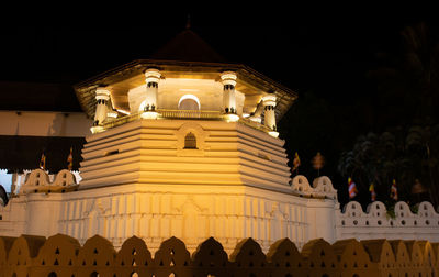 Low angle view of illuminated building against sky at night