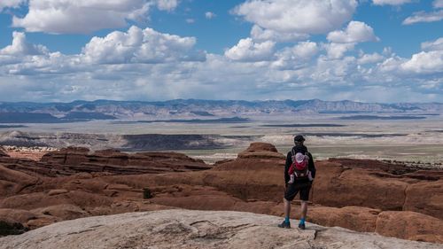 Rear view of man with baby carrier standing at arches national park