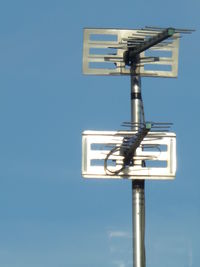 Low angle view of sign against clear blue sky