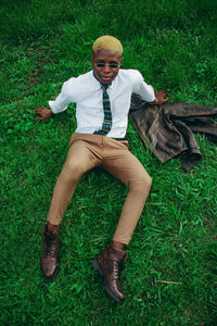 Portrait of young man lying on grass