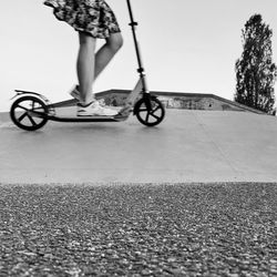 Low section of woman riding bicycle on street