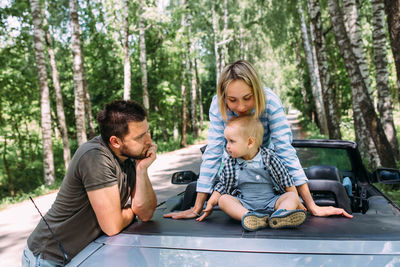 Mom, dad and little son in a convertible car. summer family road trip to nature