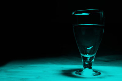 Close-up of beer glass on table against black background