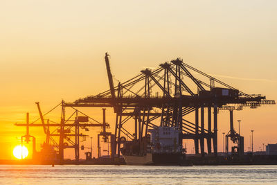 Port cranes in sunset