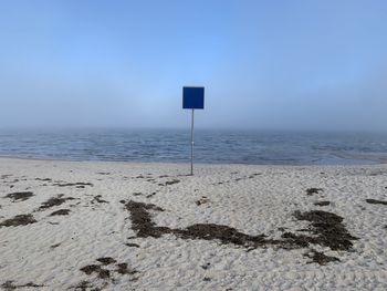 Scenic view of empty sign on beach against sky