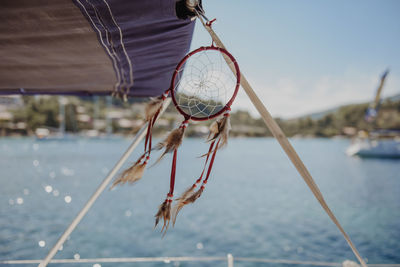 Close-up of dreamcatcher hanging on boat in sea