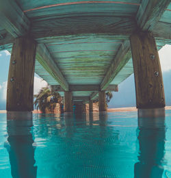 Swimming pool by sea against sky