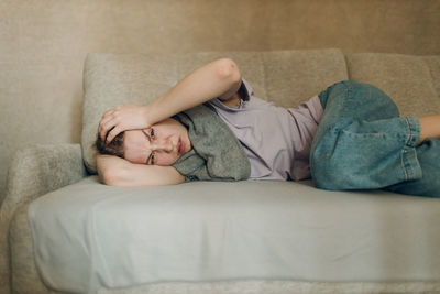 Low section of woman lying on bed at home