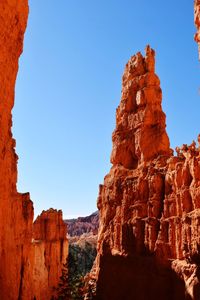 Low angle view of rock formation against clear blue sky