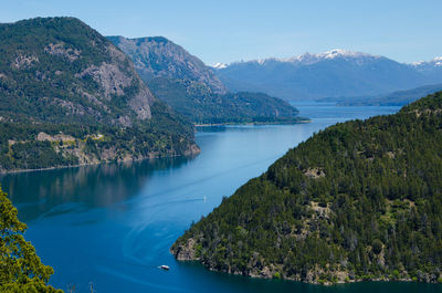 Scenic view of lake and mountains against blue sky