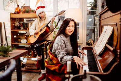 Smiling women playing piano and guitar