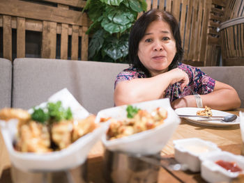 Portrait of woman sitting on table in restaurant