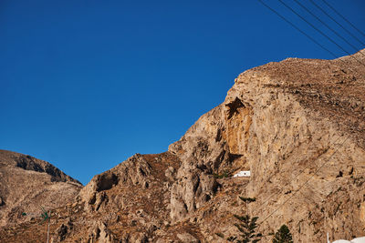 Low angle view of rock formations against clear blue sky