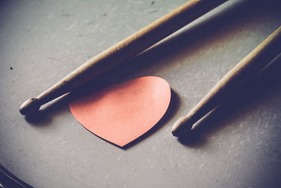 High angle view of sticks with heart shape paper on drum