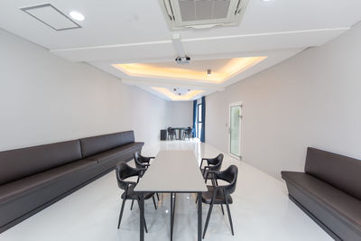 Empty chairs and tables in illuminated room