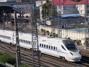 Train on railroad tracks amidst buildings in city