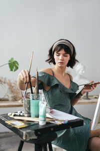 Painter sitting on stool at art studio