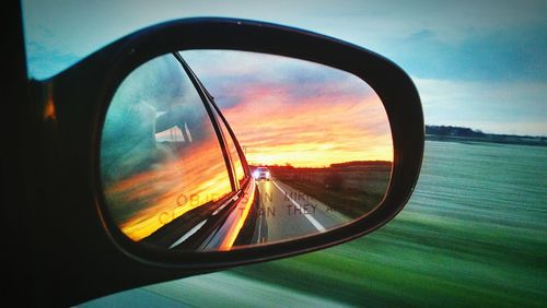 Reflection of car on road at sunset