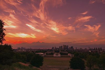 Panoramic view of cityscape against cloudy sky during sunset