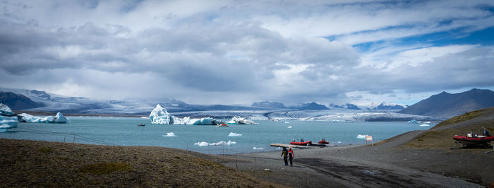 Scenic view of sea, glacier and mountains against sky