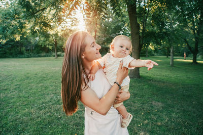 Mother and daughter against trees and plants