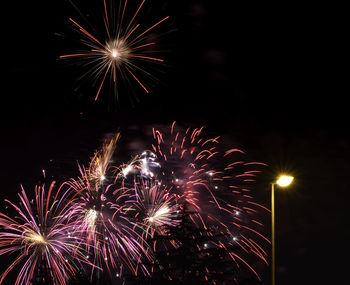 Low angle view of firework display at night