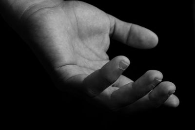 Close-up of baby hand over black background