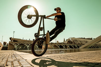 Man riding bicycle against clear sky