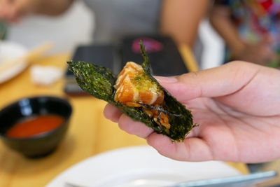 Cropped hand of woman holding food