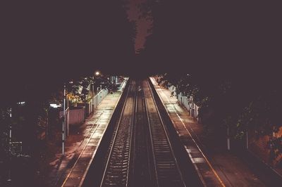 Illuminated railroad tracks at night