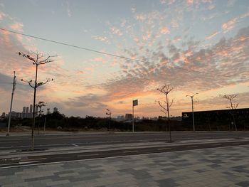 Empty road against sky during sunset