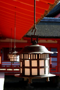 Close-up of red bell hanging outside building