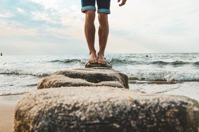 Low section of man standing on beach