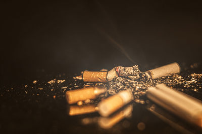 Close-up of cigarette on table against black background