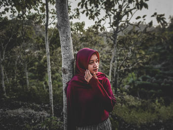 Young woman standing in forest