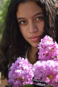 Close-up portrait of teenage girl by flowers