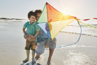 Father and little son with kite on the beach