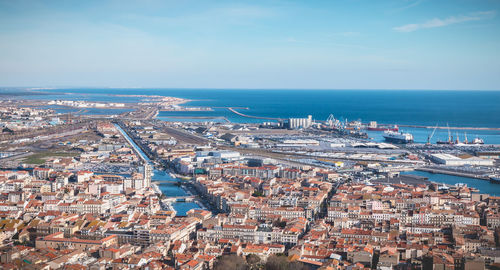 High angle view of townscape by sea against sky